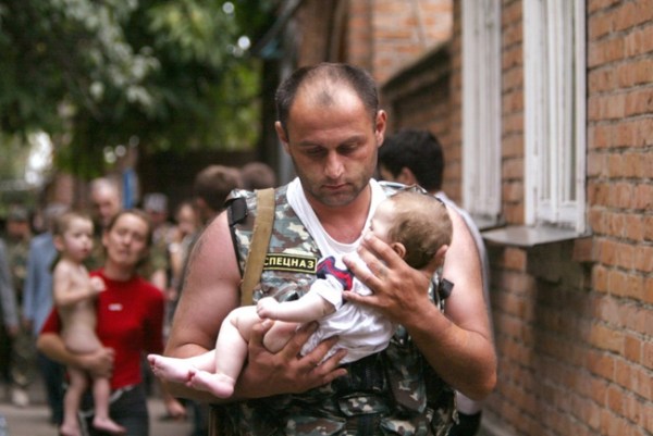 2.) A Russian police office carries a baby that was rescued from a school occupied by militants in the town of Beslan in 2004.