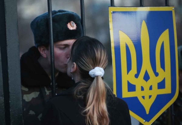 19.) A Ukrainian soldier shares a kiss with his girlfriend, while his base is surrounded by pro-Russian separatists.