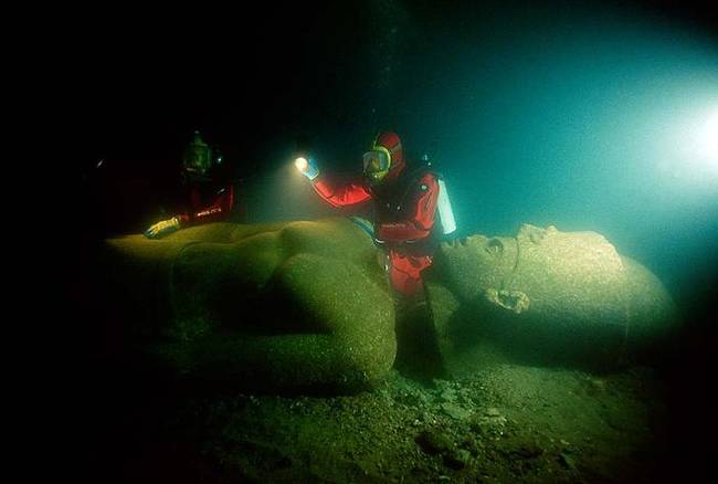 Here are some divers inspecting this ancient statue of a pharaoh.
