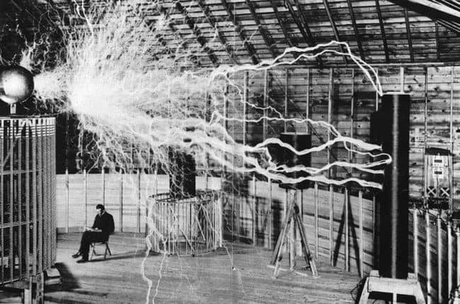 Nikola Tesla Sitting In His Laboratory With His “Magnifying Transmitter”