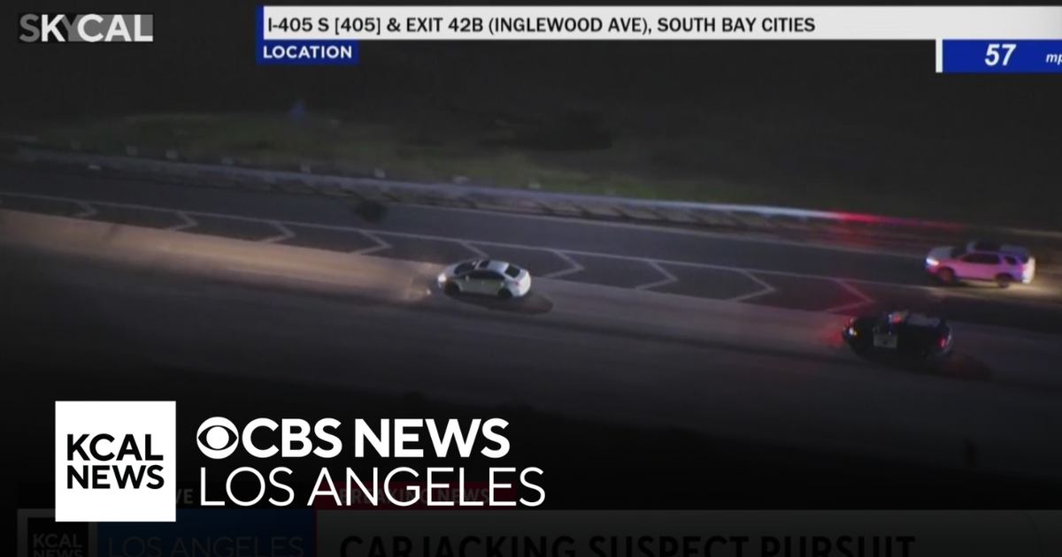 LAPD patrol vehicles pursuing the white SUV on downtown Los Angeles freeways