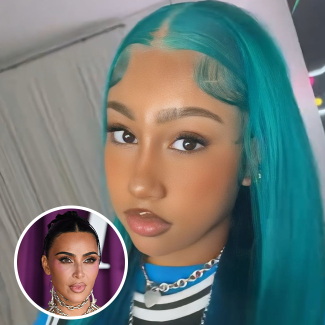 North West in electric blue hair posing in oversized grey outfit with chunky chains