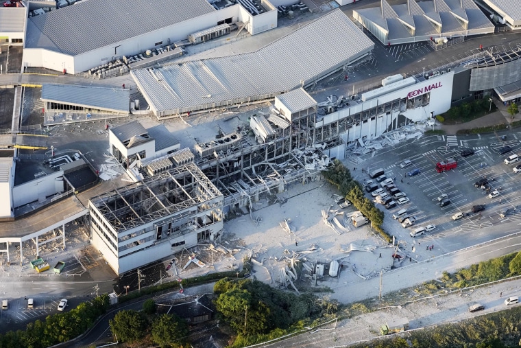 Rescue workers search the damaged Aeon Mall