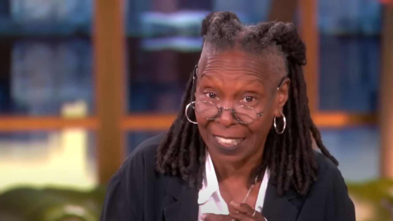 Whoopi Goldberg sitting at the moderator's seat on The View