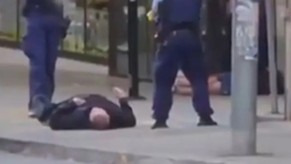 Police officer subduing a suspect on a pedestrian crossing
