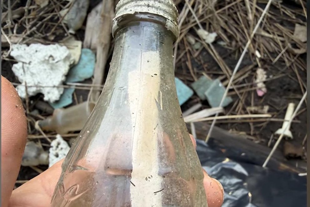 John Kauterman discovering the message bottle while cleaning wetlands