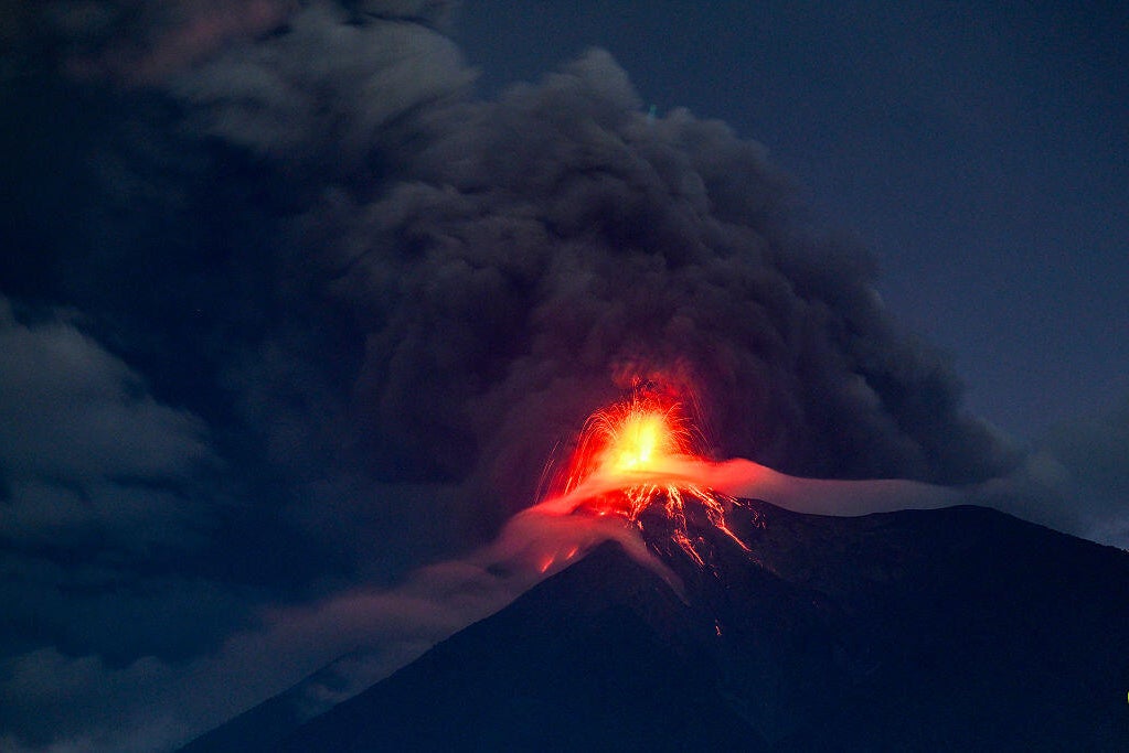 A lava fountain erupting from the Fuego volcano crater visible from San Juan Alotenango