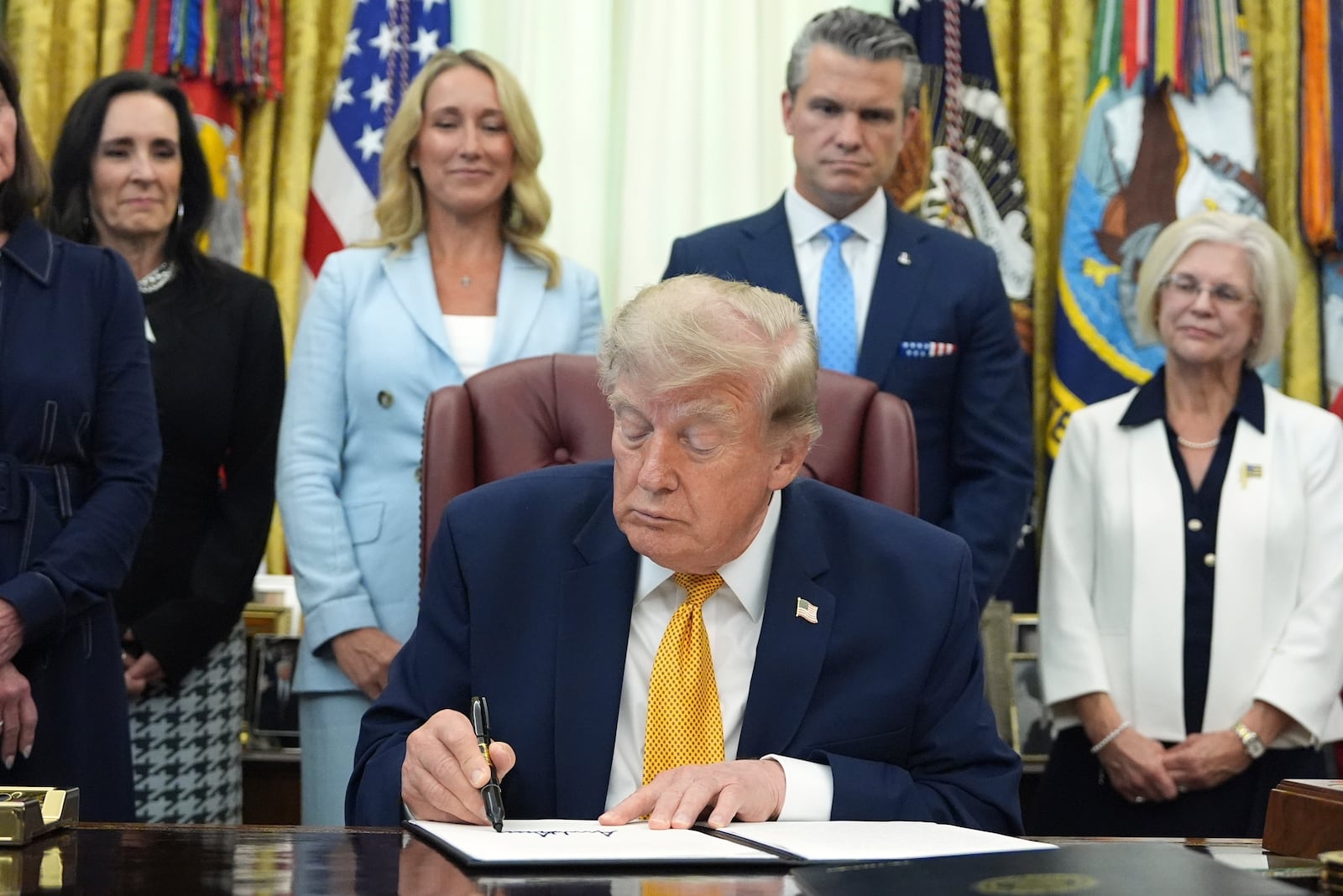 Trump signing the military spouse commission executive order in the Oval Office