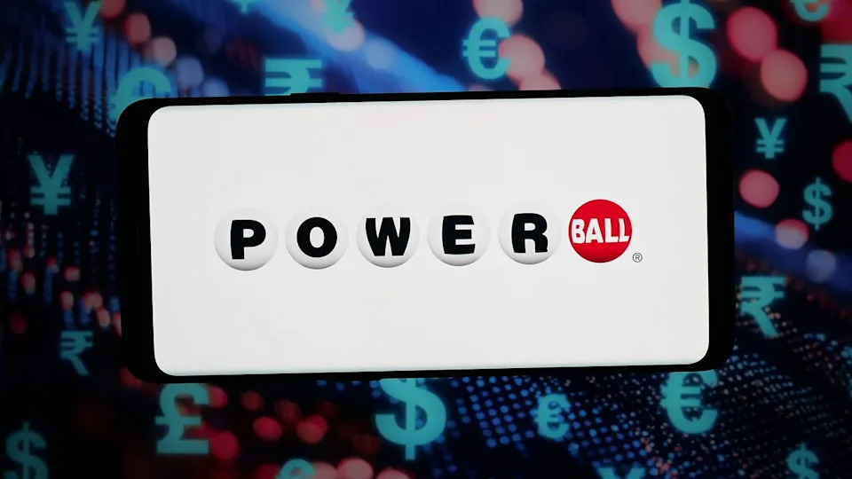 A Powerball lottery player holding a winning ticket stub