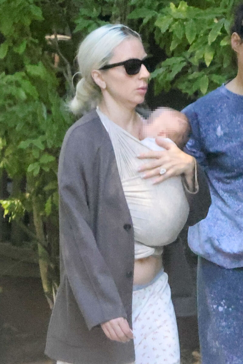 Glam Lady Gaga cradles her baby as she touches down in LA with fiancé Michael Polansky