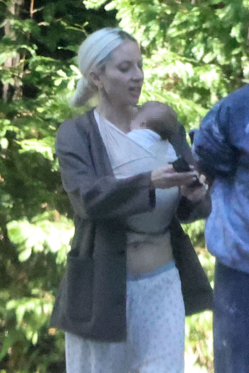 Glam Lady Gaga cradles her baby as she touches down in LA with fiancé Michael Polansky