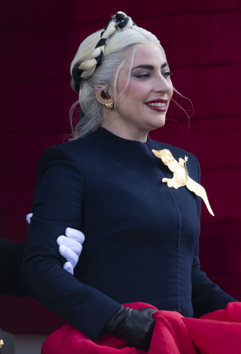 Glam Lady Gaga cradles her baby as she touches down in LA with fiancé Michael Polansky