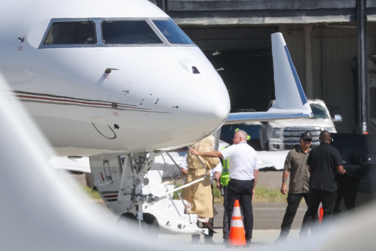 Glam Lady Gaga cradles her baby as she touches down in LA with fiancé Michael Polansky