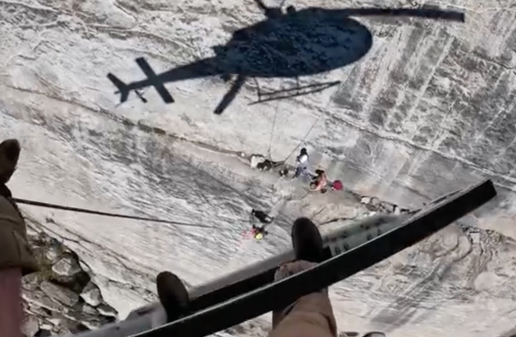 Harrowing moment helicopter hovers frighteningly close to cliff face to rescue fallen climber
