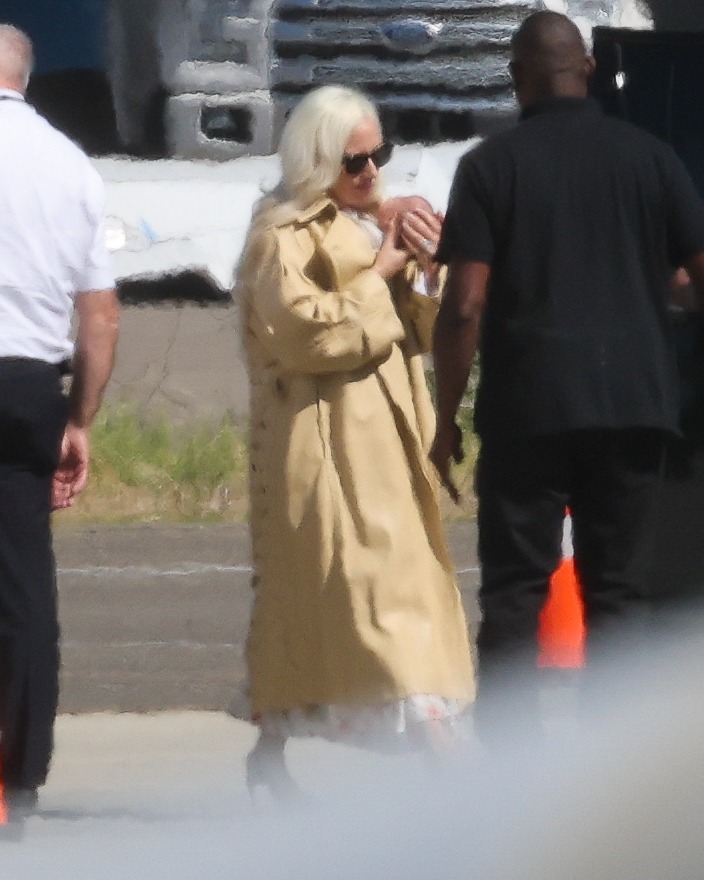 Glam Lady Gaga cradles her baby as she touches down in LA with fiancé Michael Polansky