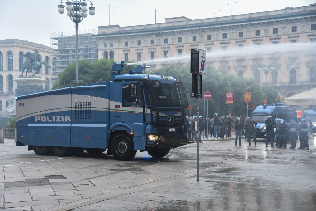 Wild moment Italian cops blast young protester with water cannon after she joined far-left rioters