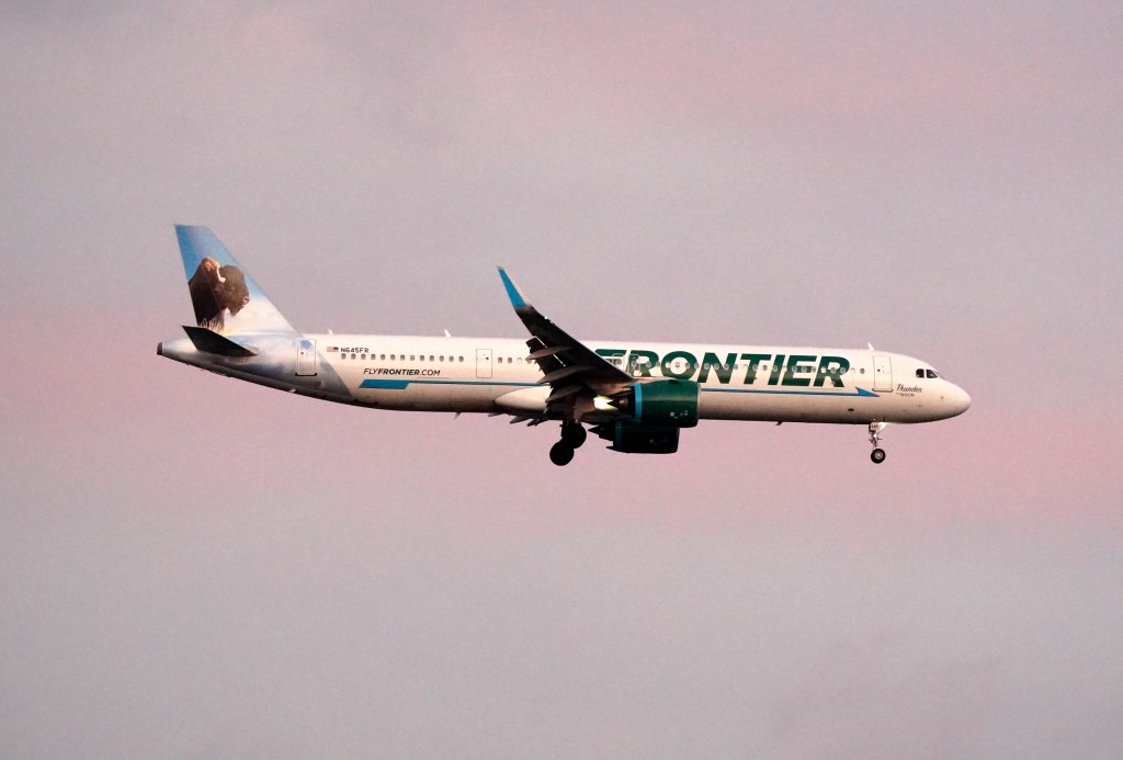 Frontier flight attendant pushes screaming passenger who appears to try to open exit door after flight is stranded at gate